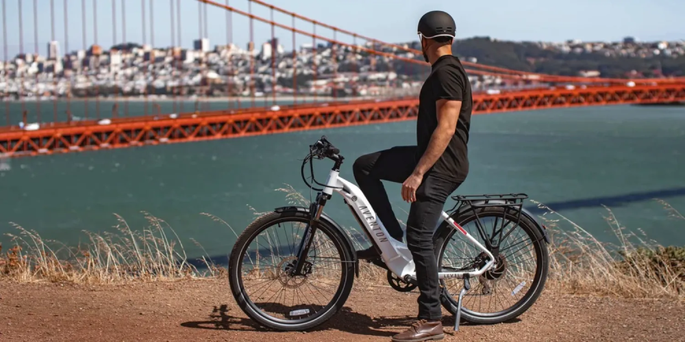 a man riding a bicycle next to a body of water