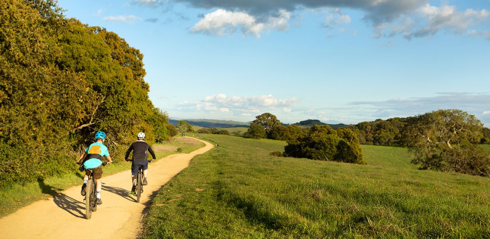 a man riding a bike down a dirt road